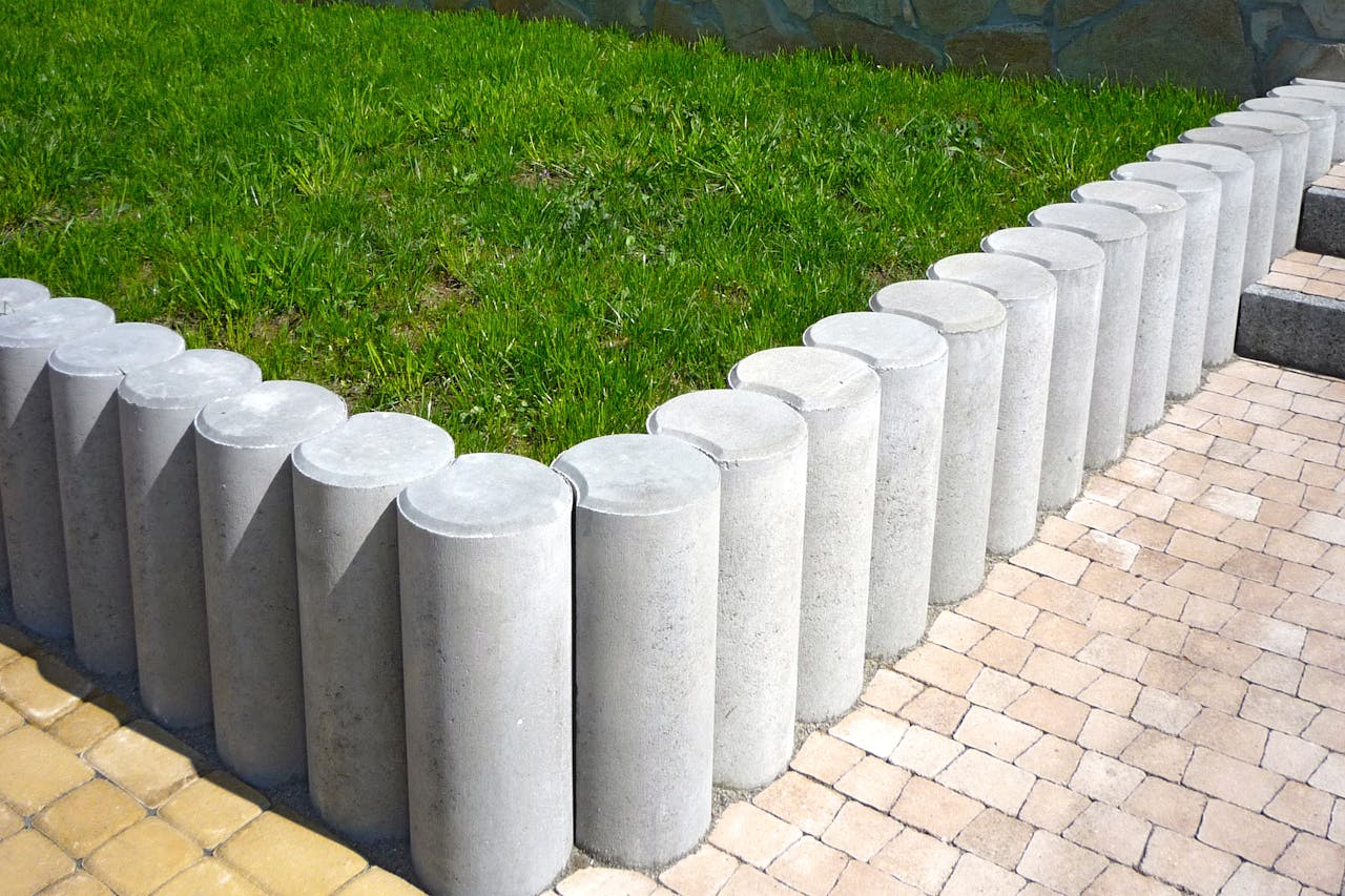 about-img-01 Cylindrical concrete blocks form a stylish lawn boundary, enhancing garden aesthetics.