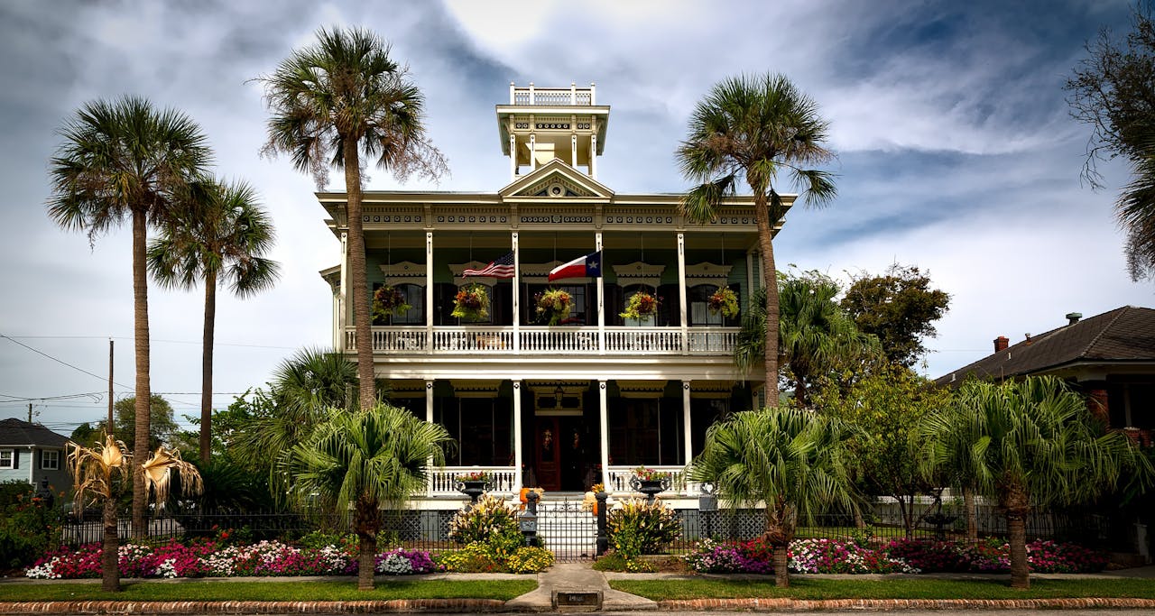 Crafting Captivating Headlines: Your awesome post title goes here Stunning view of a historic mansion with lush gardens and palm trees in Galveston, Texas.